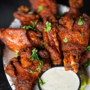 a platter of fried wings and dipping sauce