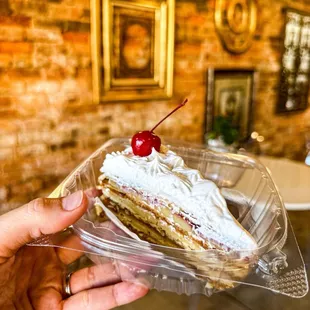 a hand holding a piece of cake