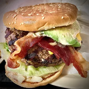 Titan burgers&apos; flagship &quot;Atlas Burger&quot; double cheeseburger has bacon &amp; avocado. Huge &amp; delicious.   I