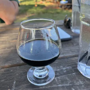 Brandy snifter glass of my Milk Stout next to water glass.