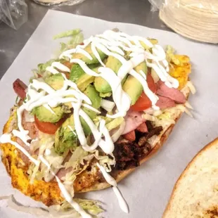 Torta Cubana ( Tito&apos;s Torta ) Comes with Steak , Chorizo , Egg , Ham , Lettuce , Tomato , Avocado , Sour cream and Cheese .