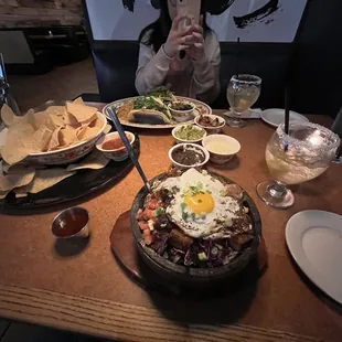 a woman taking a picture of a table full of food