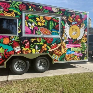 a colorful food truck parked on the side of the road