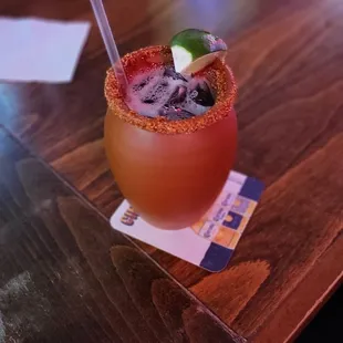 a cocktail with a lime garnish