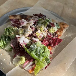 Pepperoni slice with salad on top