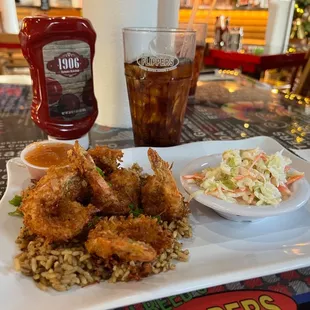 Coconut shrimp on a bed of dirty rice with gravy coleslaw