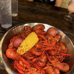 a bowl of crawfish, corn and potatoes