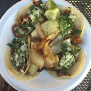 2 carne asada and 2 al pastor tacos hooked up with the grilled onions on top