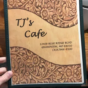 a hand holding a menu