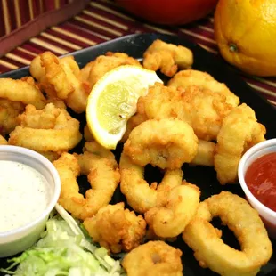 a plate of deep fried calamails and dipping sauce