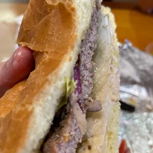 a hand holding a sandwich