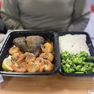 a woman holding two trays of food