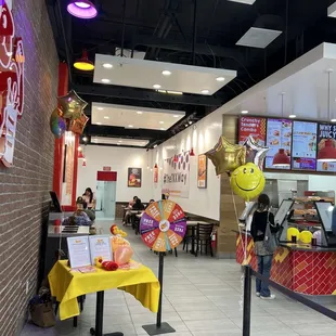 Grand opening photo of the prize wheel inside the store with customers eating