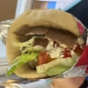  a hand holding a sandwich