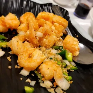 shrimp and vegetables on a black plate