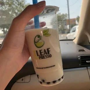 a hand holding a cup of iced tea