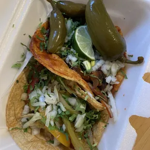 Grilled veggie taco and mushroom taco with a side of pickled jalapeños