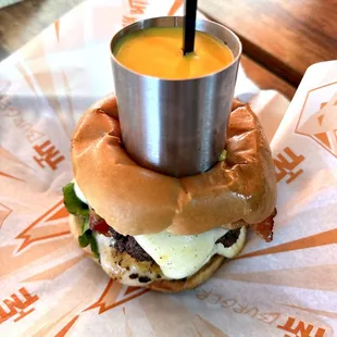 a hamburger with a cup of sauce