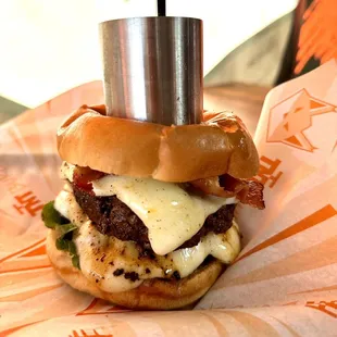 a burger with a pepper shaker on top