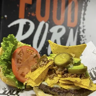 Nacho Burger- topped with pepper jack cheese, tortilla chips, pico de gallo, melted cheddar cheese, jalapeño slices, avocado, and chili
