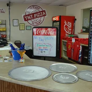 a counter with three pizza pans on it