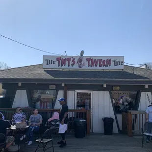 Folks sitting on the deck having fun under the sign