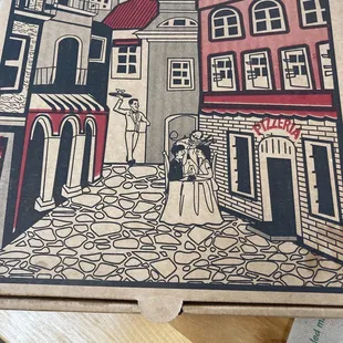 a pizza box with a drawing of a couple on a cobblestone street