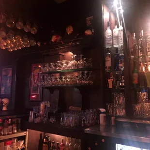 a bar with a lot of glasses on the shelves