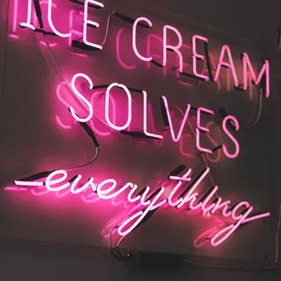 a neon sign that says ice cream solves everything