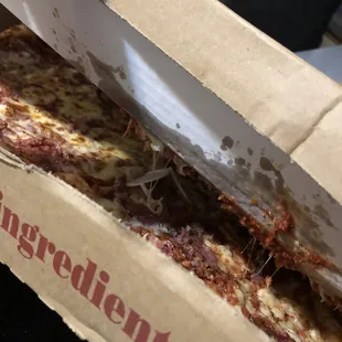 a person cutting a slice of pizza