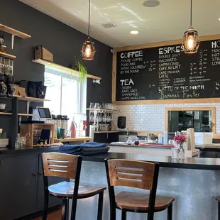 a coffee shop with a menu on the wall