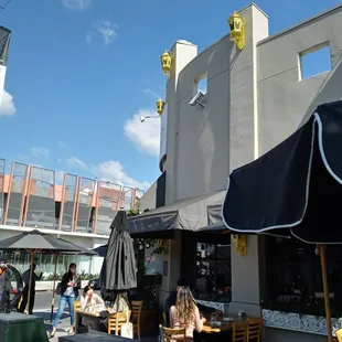 people sitting at tables under umbrellas