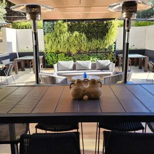 a table and chairs under a pergol roof