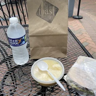 a bowl of soup and a paper bag on a table