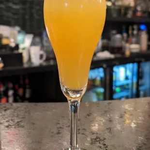 a glass of orange juice on a bar