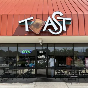 the front of a restaurant with tables and chairs