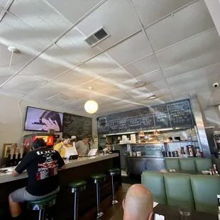 a man sitting at a counter in a restaurant