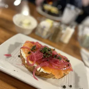 Smoked salmon toast with jalapeño cream cheese, capers and pickled onions. It normally has hard boiled egg but I got it on the side.