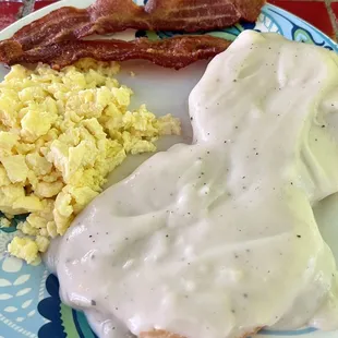 Biscuits and gravy with scrambled eggs and bacon.