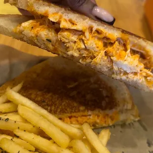 a person holding a sandwich and french fries