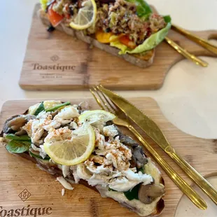 two slices of bread on a cutting board with a knife and fork