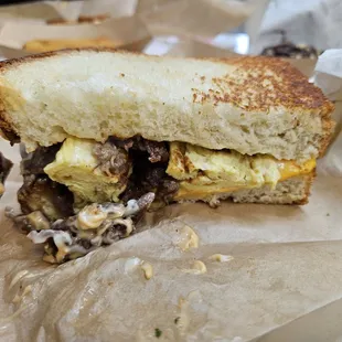 Bulgogi Egg Drop sandwich cut in half, Bulgogi on the top, left side, bottom all egg