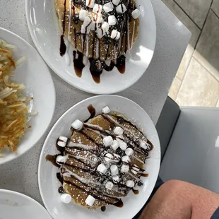 a plate of waffles with chocolate syrup and marshmallows