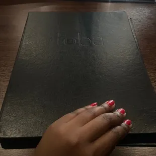 a woman's hand on a menu