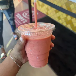 Orange juice, banana, and frozen strawberries blended together.