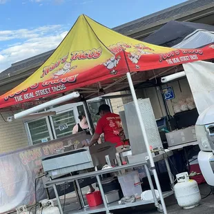 a man preparing food under a tent