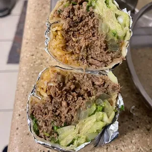 two burritos sitting on a counter