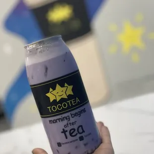 a hand holding a can of tea