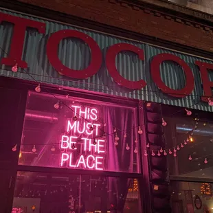 a neon sign in the window of a restaurant