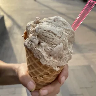 a person holding a cone of ice cream